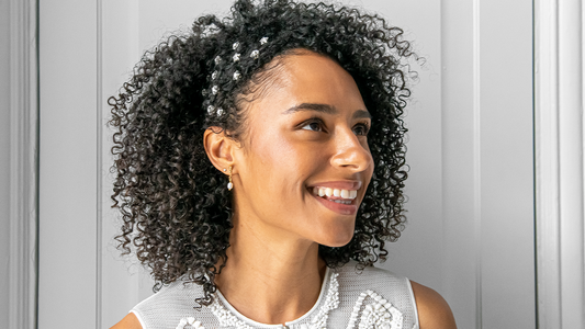 Femme aux cheveux noirs et bouclés, coiffée pour un mariage