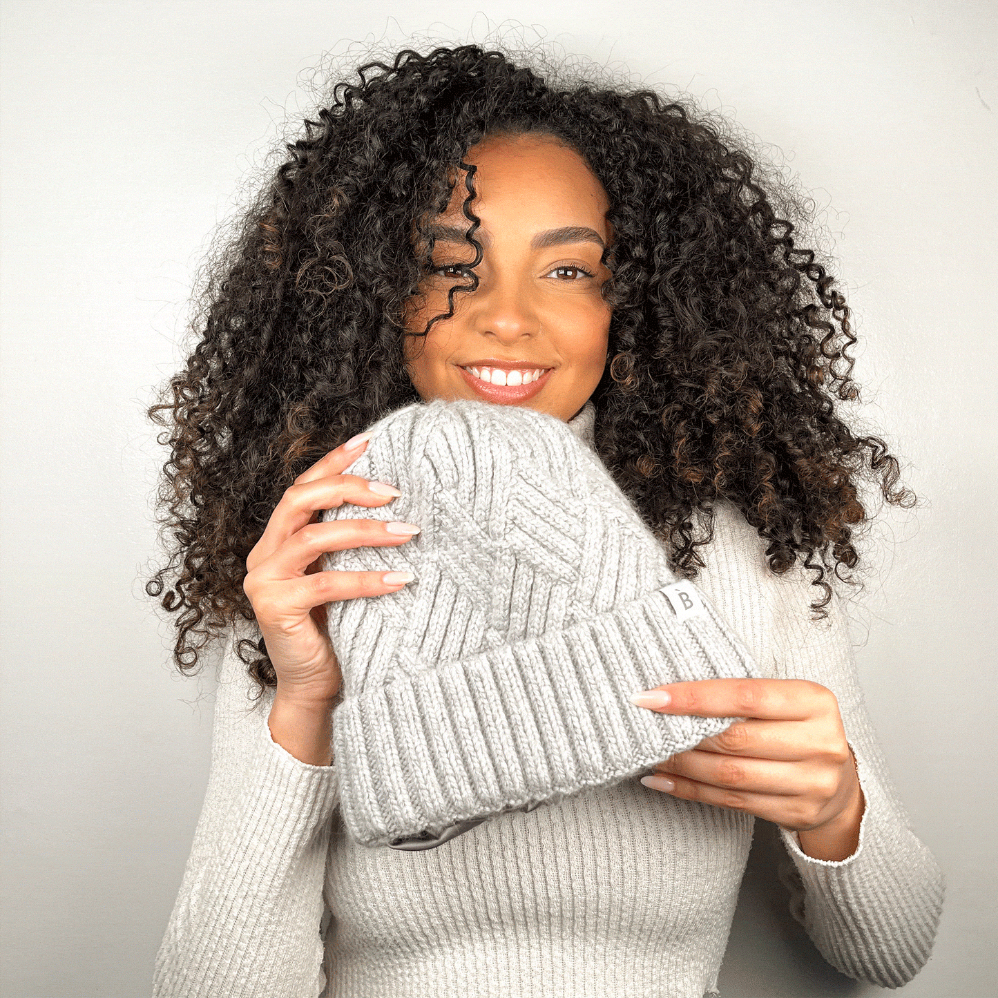 Modèle aux cheveux frisés portant un bonnet doublé de soie