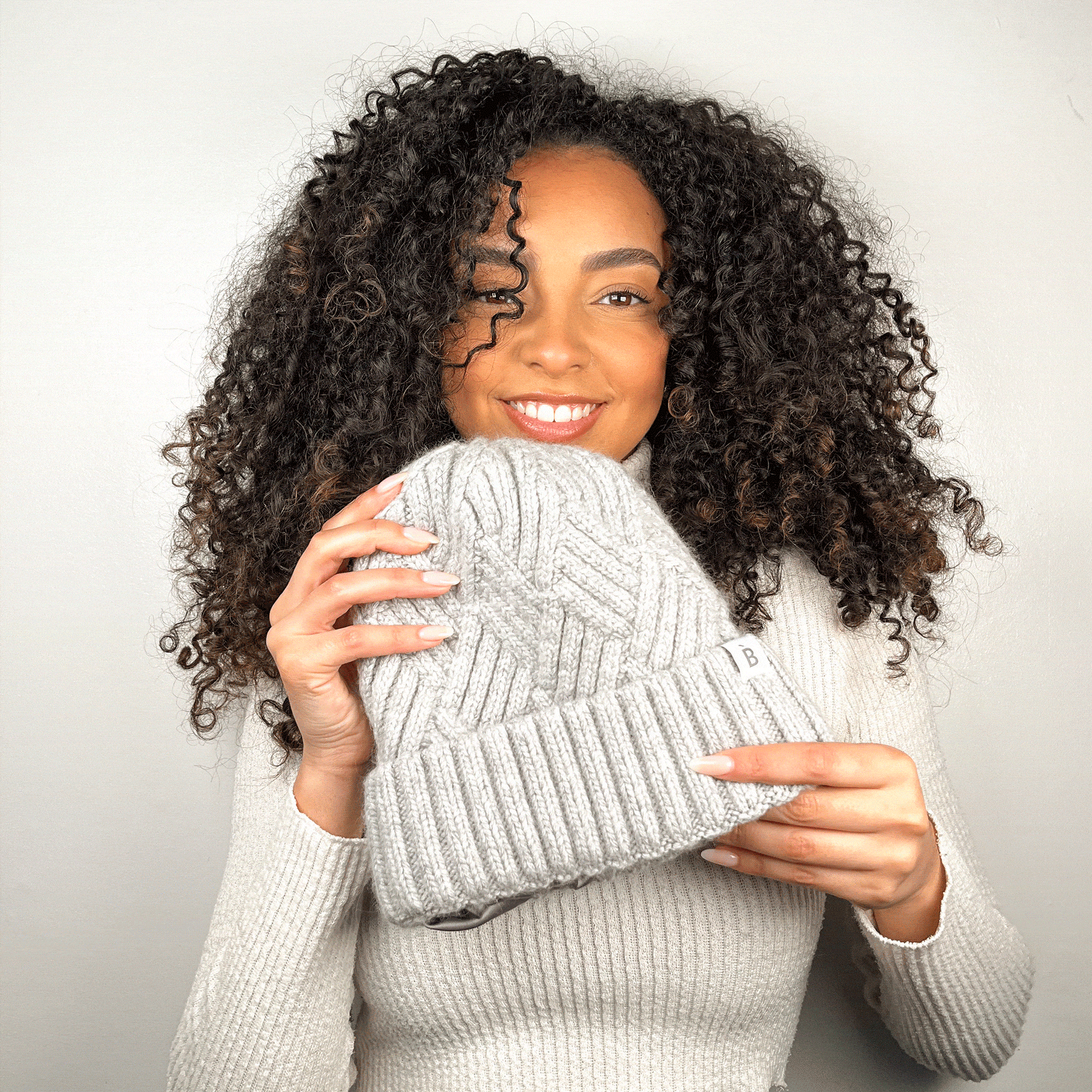 Modèle aux cheveux frisés portant un bonnet doublé de soie