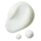Gros plan sur la texture de la mousse super-volumisante, dont la consistance légère, aérée et mousseuse se détache sur un fond de crème.