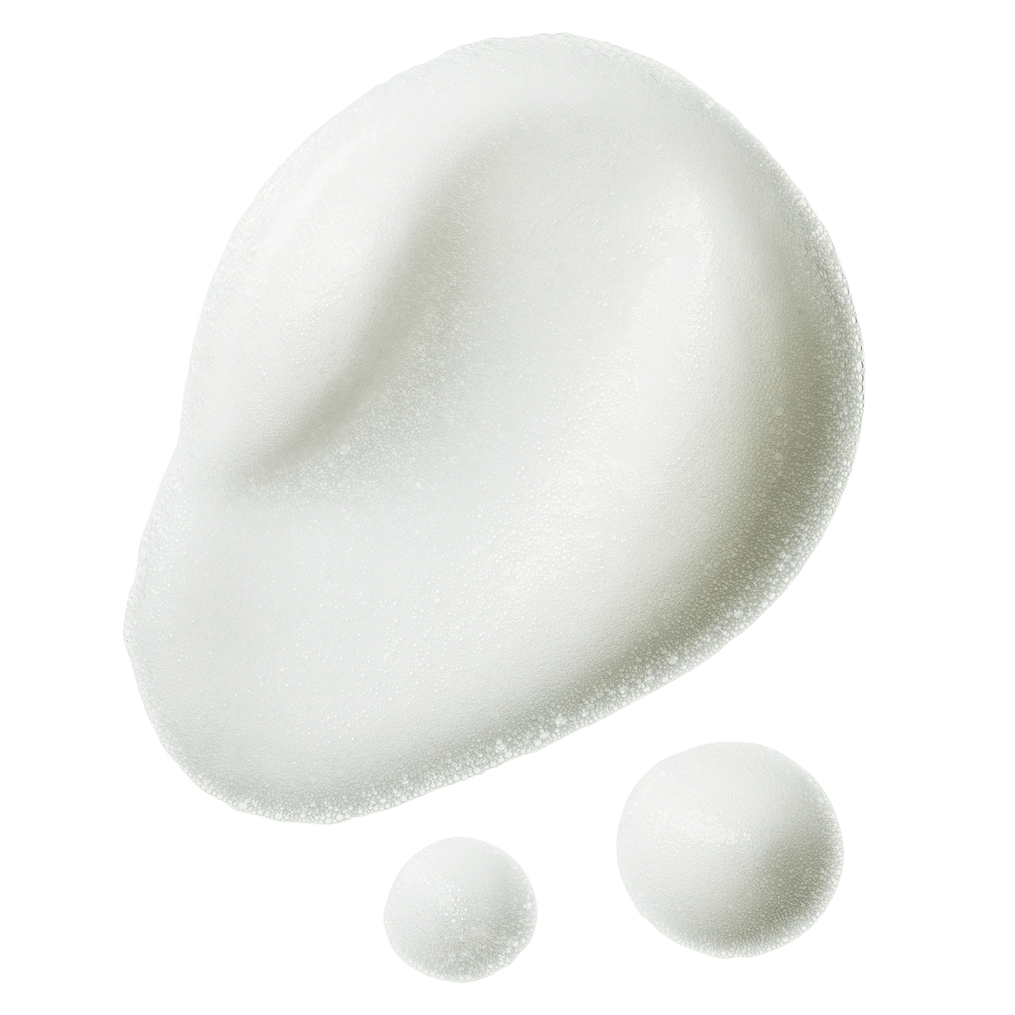 Gros plan sur la texture de la mousse super-volumisante, dont la consistance légère, aérée et mousseuse se détache sur un fond de crème.